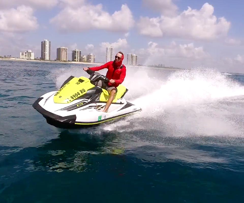 Guy in a red wetsuit riding Yamaha Jet Ski